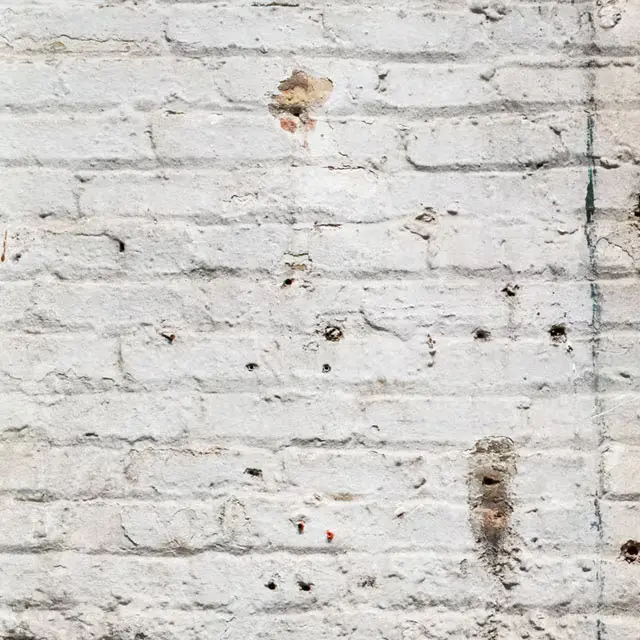 A photograph of a dry brick wall representing dry skin.